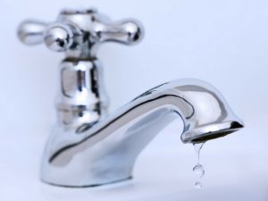 Chrome faucet with a visible drip, illustrating water leak issues relevant to plumbing and maintenance services by Force Plumbing and Heating LLC.