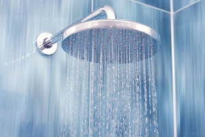 Shower head with water cascading down, illustrating plumbing device functionality relevant to replacement advice from Force Plumbing and Heating LLC.