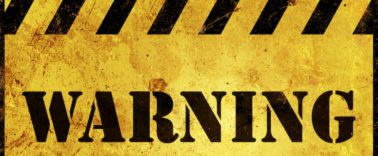 Warning sign with bold black text on a distressed yellow background, emphasizing the importance of safety and legal compliance in plumbing and heating remodeling projects.