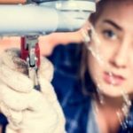 Person in gloves using an adjustable wrench to repair a leaking pipe for Force Plumbing and Heating LLC.