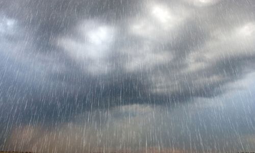 Dark storm clouds with heavy rain falling, illustrating potential plumbing issues during the rainy season.