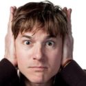 Man covering his ears, expressing concern about plumbing noises, relevant to emergency plumbing services and home maintenance tips.