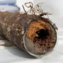 Decaying metal pipe showcasing rot and hollow interior, featured in Force Plumbing and Heating's educational content.