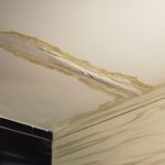 Damaged ceiling with peeling area and exposed materials, highlighting potential plumbing issues by Force Plumbing.