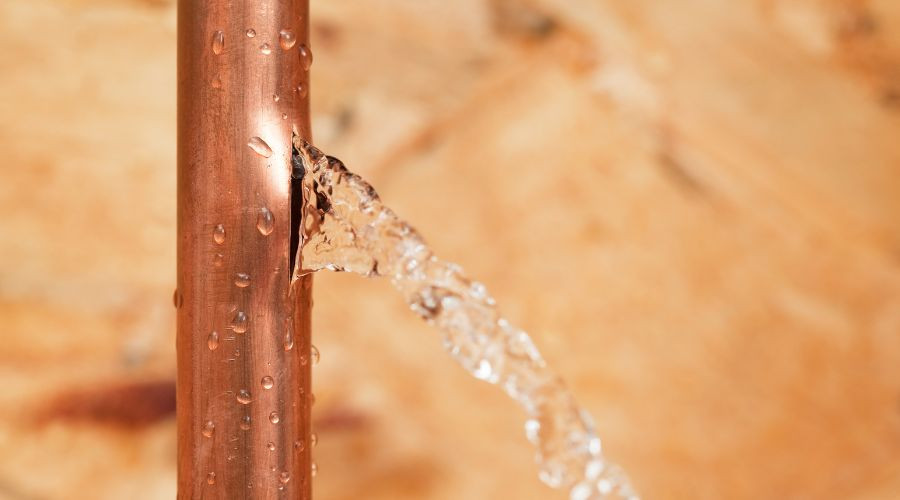 Water leaking from a copper pipe, showcasing plumbing issues relevant to water leak identification and repair services offered by Force Plumbing and Heating LLC.